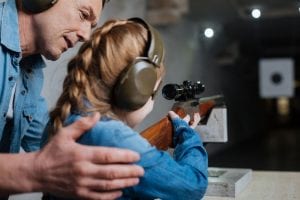 father teaching daughter about firearm safety